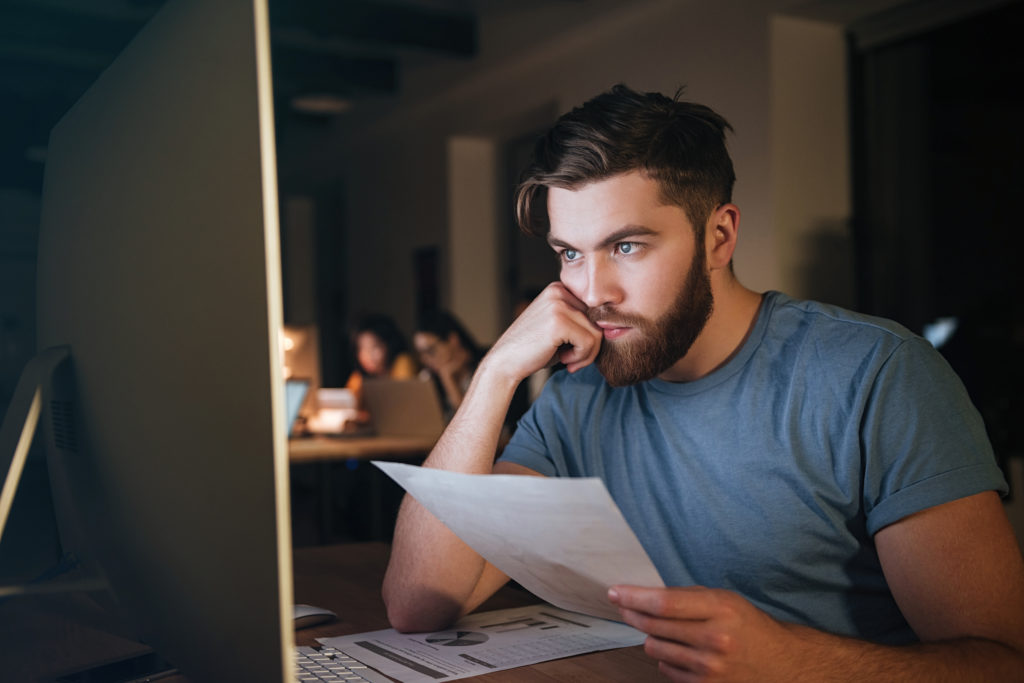 Man looking at computer with confused look.