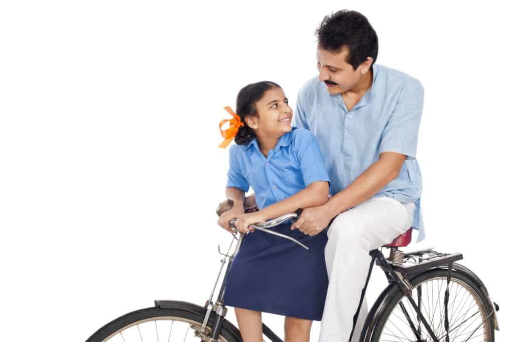 Happy girl and her father on a bicycle